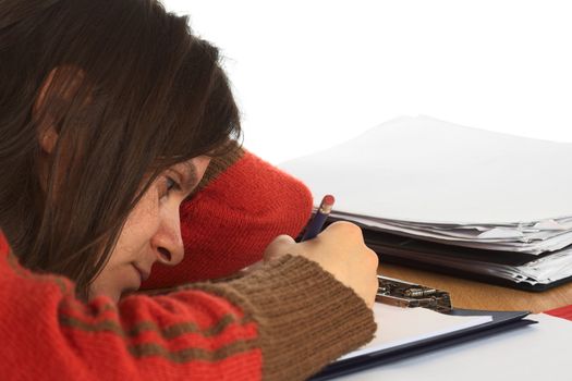 Very tired young Caucasian woman trying to write and study. Isolated on white (Selective Focus, Focus on the right eye and right side of the face)