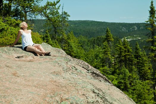 Girl relaxing on a rock in the middle of the nature