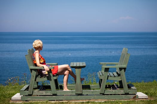 Girl having a beautiful moment on a bench in vacation