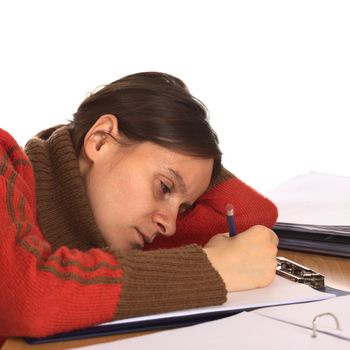 Very tired young Caucasian woman trying to write and study. Isolated on white (Selective Focus, Focus on the right eye and right side of the face)