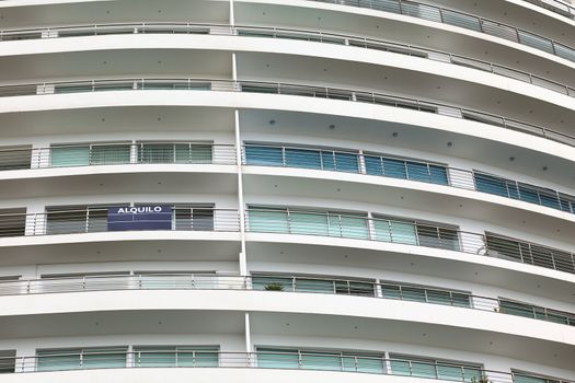Detail of a modern multi-storey apartment building with balconies (alquilo means for rent)