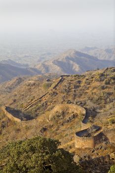 Portrait of the Kumbhalghar Fort walls seen stretching over the hilly Rajasthan terrain and into the distance