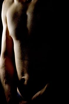 sexy fit naked male body on black background low key