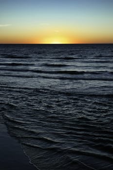 sun is setting over the sea at semaphore south australia