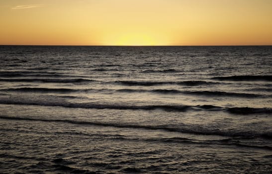 sun is setting over the sea at semaphore south australia