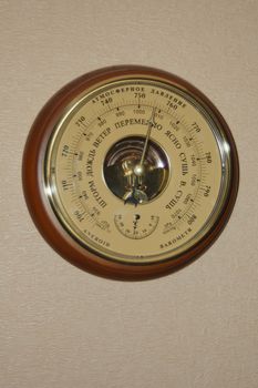 aneroid barometer on the wall with pink wallpaper