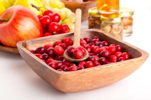 Fresh red cranberries in the wooden bowl with spoon