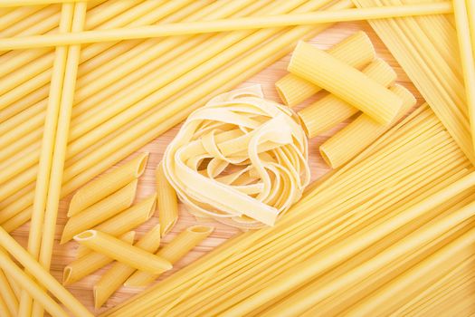 Different kinds of italian pasta on the wooden background 