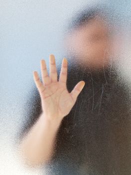 Silhouette of a man's body through frosted glass