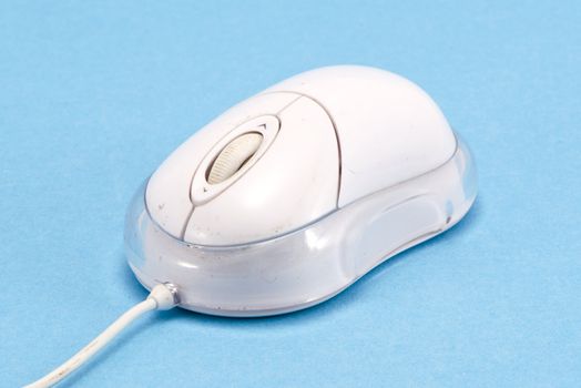 Old used white computer mouse on blue background. Device for pc control.