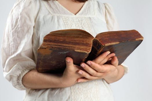 Photo of a female holding an open bible from 1786 in her hands.