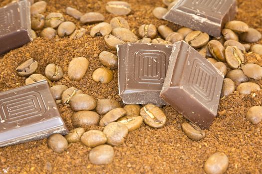 Chocolate and coffee beans on a bed of coffee powder