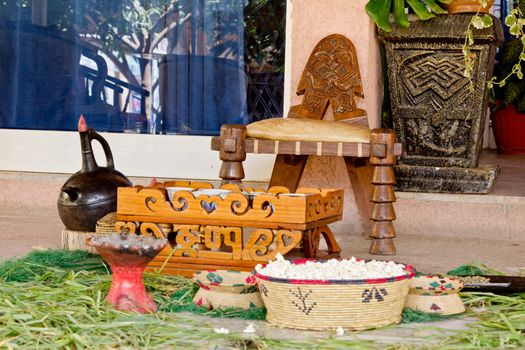 The setup of a traditional coffee cerimony with a clay coffee pot, pop corn, hand crafted chair and coffee table.