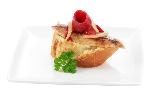 appetizer dish typical of the spanish cuisine of mackerel fillet with red pepper and onion on slice of bread cut off and isolated