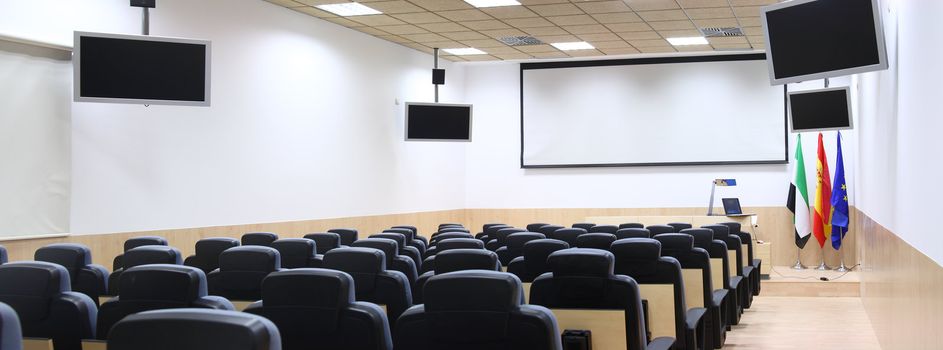 conference room equipped with modern screen monitors and armchairs