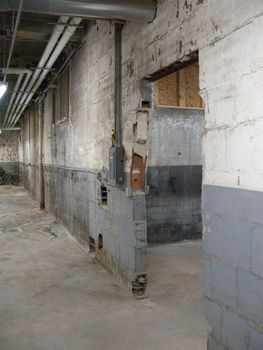 Empty older warehouse / industrial space with grey  white walls