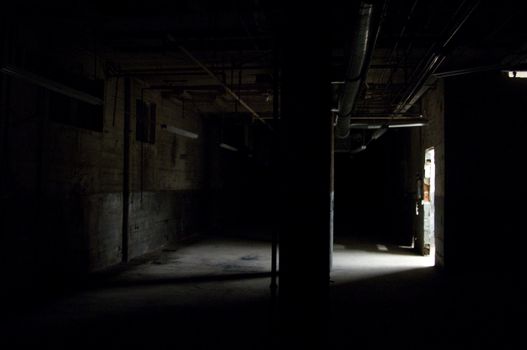 Dark empty warehouse / commercial space with shaft of light