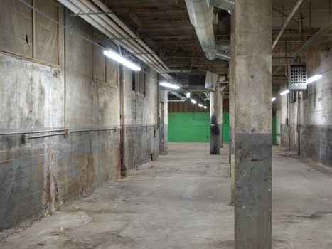 Empty older warehouse / industrial space with grey  white walls