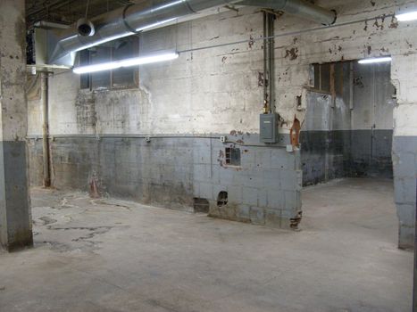 Empty older warehouse / industrial space with grey  white walls