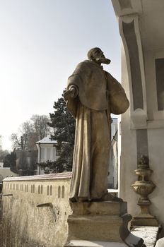 A statue of the priest at the entrance to the castle Krumlov