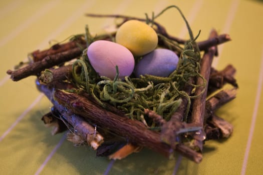 Miniature bird nest with candy eggs.