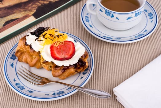 Fresh cream puff with whipped cream and strawberry.