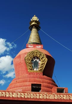 Historic red stupa in Tibet against blue sky