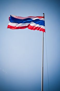 Flag of Thailand with flag pole waving in the wind blue sky