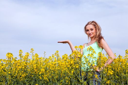 young beautiful blonde girl in a field in summer happy