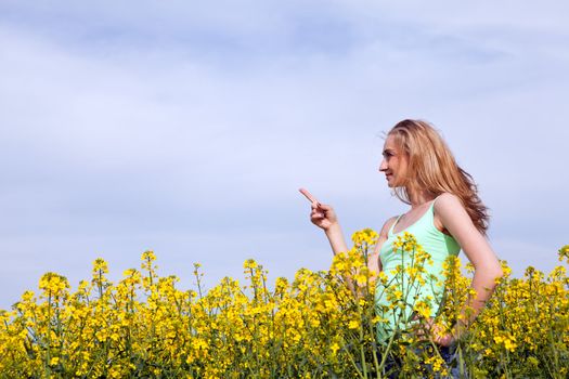 young beautiful blonde girl in a field in summer happy