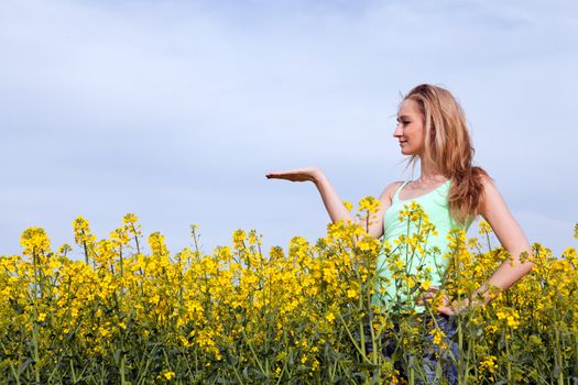 young beautiful blonde girl in a field in summer happy