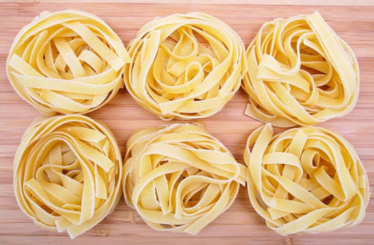 Tagliatelle pasta on the wooden background