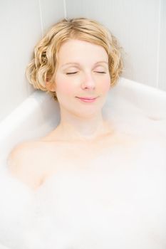 Happy young woman relaxing in the bath