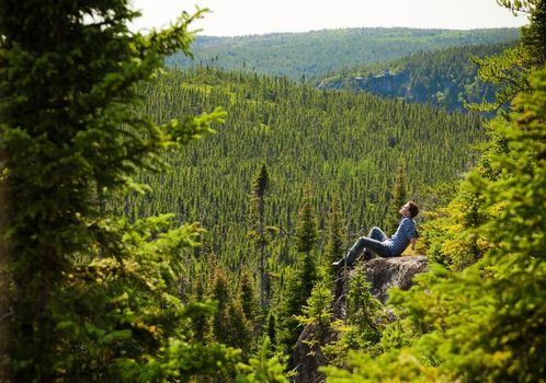 Young man relaxing on a rock in the middle of the nature