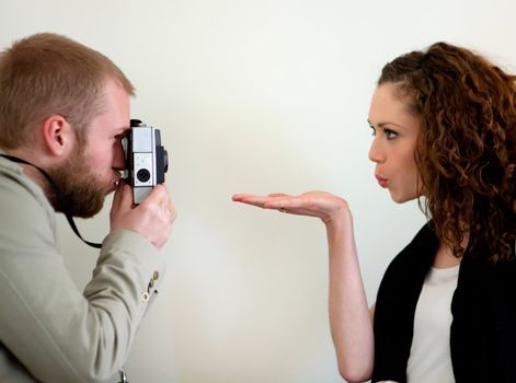 Photographer and a model flirting and sending a air kiss.