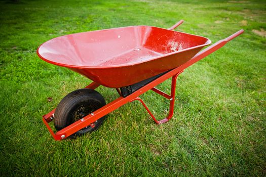 Red wheelbarrow in the middle of the lawn