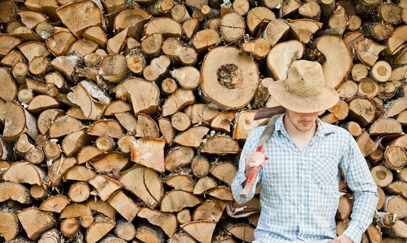 Woodcutter with straw hat on a background of wood