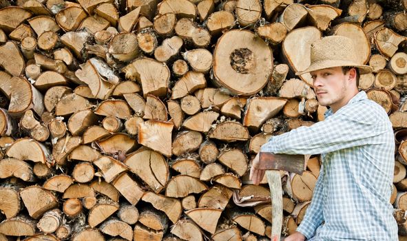 Woodcutter with straw hat on a background of wood