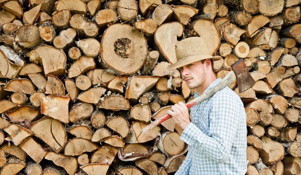 Woodcutter with straw hat on a background of wood