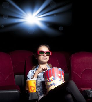 young woman sitting alone in the cinema and watching a movie