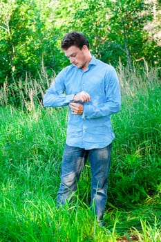 Young man in nature adjusting cufflinks and getting ready