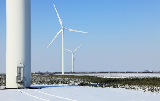 Image of a field with wind turbines during the winter.