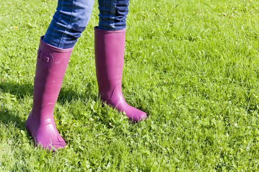 detail of woman wearing rubber boots on lawn