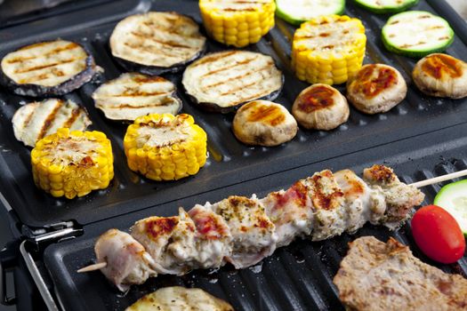 meat skewer and vegetables on electric grill