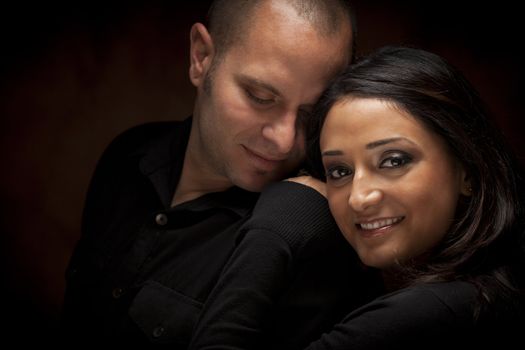 Happy Mixed Race Couple Flirting with Each Other Portrait Against A Black Background.