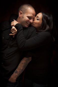 Happy Mixed Race Couple Flirting with Each Other Portrait Against A Black Background.