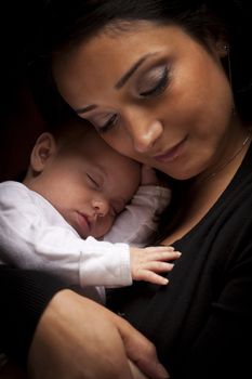 Young Attractive Ethnic Woman Holding Her Newborn Baby Under Dramatic Lighting.