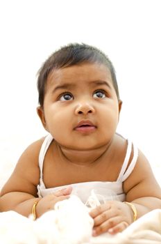 6 months old Indian baby girl having thought, looking up