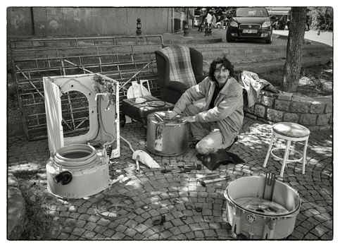 WASHING MACHINE BUILDER, USKUDAR, ISTANBUL, TURKEY, APRIL 16, 2012: Dexterous Turkish man building new washing machines out of spare parts from old ones. His business take place in the street.