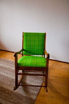 Wooden rocking chair with green fabric on